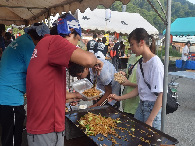 屋台を手伝う学生